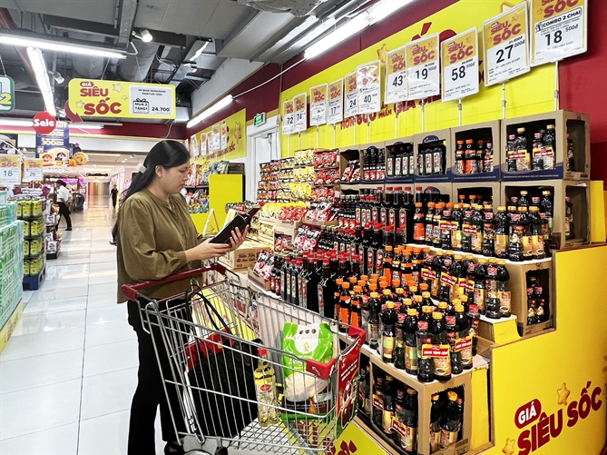 A customer browses discounted seasoning products at WinMart supermarket.